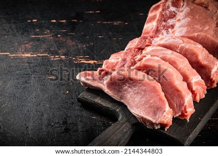 Raw pork on a cutting board. Against a dark background. High quality photo