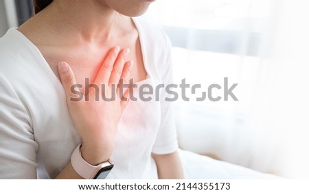 Young woman putting her hand on her chest. Having a pain in chest, Gastroesophageal Reflux Disease  have frequent belching. Healthcare medical concept.  Royalty-Free Stock Photo #2144355173