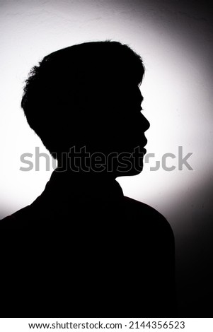 Silhouette of a young Asian man facing to the right.