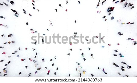 Aerial Drone View Flight Over many people in colorful clothes skating on an open-air ice rink in winter. Ice skating top view. City Park Ice Rink. Winter outdoor activities. Skating sport background Royalty-Free Stock Photo #2144360763