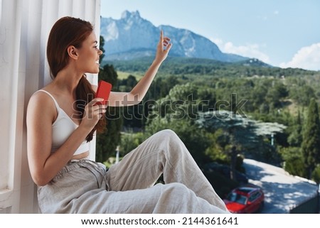 beautiful woman use the phone looks at the screen in a comfortable hotel an open view of the Relaxation concept