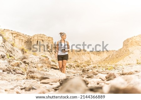 Explorer standing in mountainous terrain in desert
