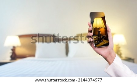 Hand holding smartphone take photo room at hotel