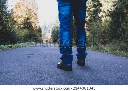 Man walking down on a forest road.
