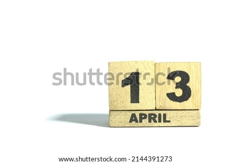 April 13. 13th day of the month, wooden calendar isolated on a white background with shadow.