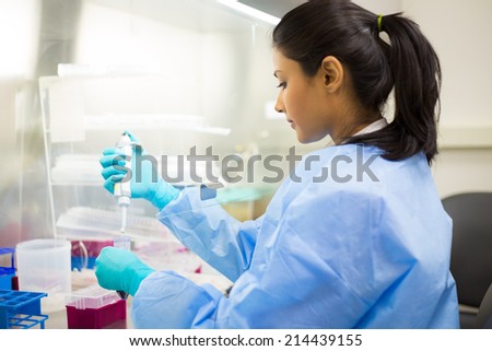 Closeup portrait, scientist holding 50 mL conical tube with blue liquid solution, performing laboratory experiments, isolated lab background. Forensics, genetics, microbiology, biochemistry Royalty-Free Stock Photo #214439155