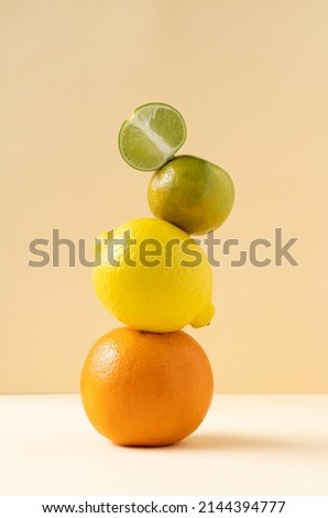 Citrus pyramid: orange, lime, tangerine and lemon balance on a yellow background. Balancing citrus fruits on the table, copy space. Equilibrium floating food balance. Royalty-Free Stock Photo #2144394777