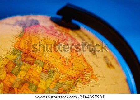 A table lamp in the form of a globe, a rotating globe of the earth on a blue background. Georgafia of the whole world. Close-up.