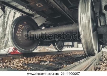 Wheel pairs of a freight railway car. Wheeled trolley of a train car. Steel wheels on rails of the railway. Selective focus Royalty-Free Stock Photo #2144400057