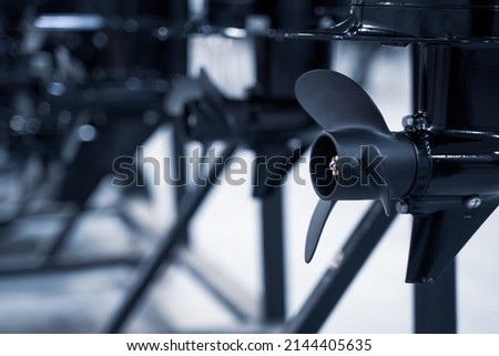 perspective view closeup of row of black boat ship propellers Royalty-Free Stock Photo #2144405635