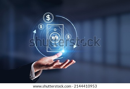 Businessman hand hold digital hologram banknote and lines, blurred dark background. Cashback and money refund. Concept of payment and transaction Royalty-Free Stock Photo #2144410953