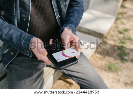Credit card, young man's credit card is standing on his phone, online shopping preparation and bill payment, paid subscriptions and content payments
