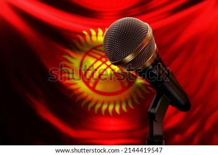 Microphone on the background of the National Flag of Kyrgyzstan
, realistic 3d illustration. music award, karaoke, radio and recording studio sound equipment