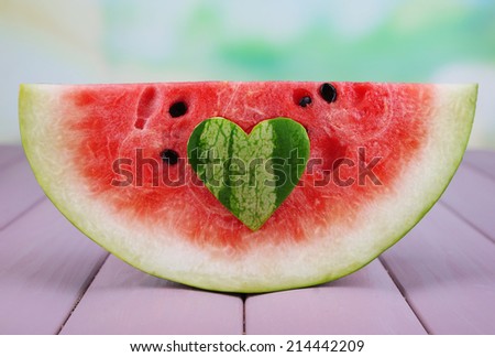Slice of watermelon on wooden table on natural background