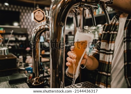 bartender pouring beer into a glass at the bar