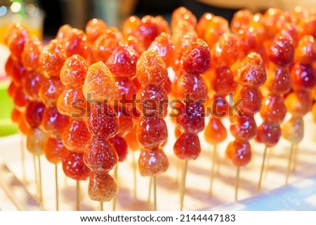 The sugar coated strawberry skewers are embroidered on the foam board. Tanghulu crispy fruit Royalty-Free Stock Photo #2144447183