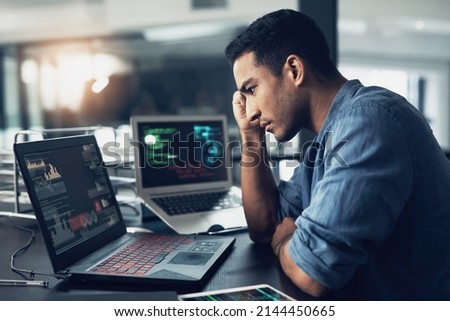 Lifes a game with no reset on the end. Shot of a young man suffering from a headache while using a laptop in a modern office.