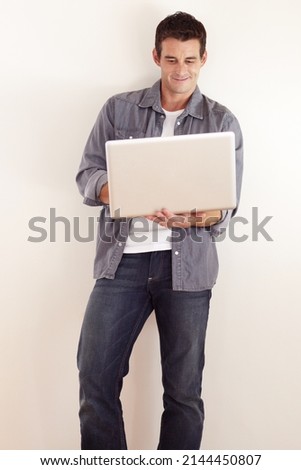 Accessing the internet from anywhere. A handsome young man working on his laptop.