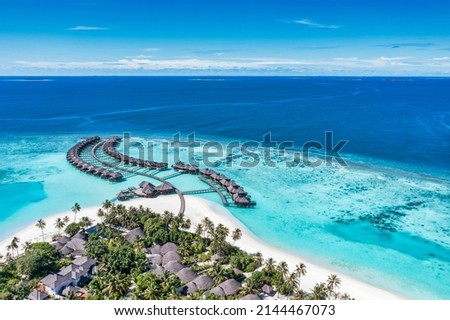 Maldives paradise island. Tropical aerial landscape, seascape with jetty, water bungalows villas with amazing sea lagoon beach. Exotic tourism destination, summer vacation background. Aerial travel Royalty-Free Stock Photo #2144467073