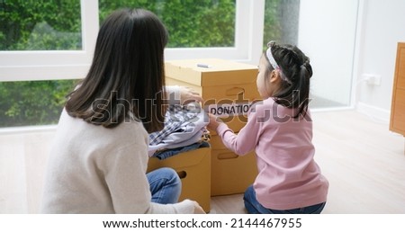 Small gift donate for social issue relief alms unity care at home. Asia little girl kid and mom happy smile help poor people by reuse old used clean clear closet sort stack box zero waste eco saving.