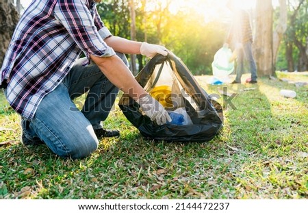 Collecting the garbage and separating waste to freshen the problem of environmental pollution and global warming, plastic waste, care for nature. Volunteer concept of men carrying garbage bags Royalty-Free Stock Photo #2144472237