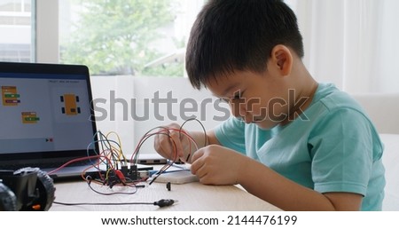 Asia home school young small kid happy smile self study online lesson excited make AI circuit toy. STEM STEAM digital scratch class on laptop screen for active children play arduino enjoy fun hobby. Royalty-Free Stock Photo #2144476199