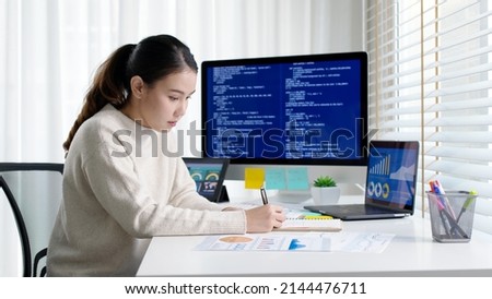 Asia young business woman sit busy at home office desk work code on desktop reskill upskill for job career remote self test IT deep tech ai design skill online html text for cyber security workforce. Royalty-Free Stock Photo #2144476711