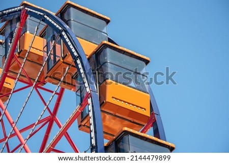 Colorful Orange Passenger Cabins on Red White and Blue Ferris Wheel Royalty-Free Stock Photo #2144479899