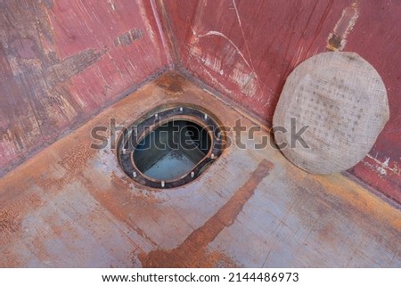 Bilge well in open condition with cover wrapped in burlap, inside cargo hold of bulk carrier ship Royalty-Free Stock Photo #2144486973