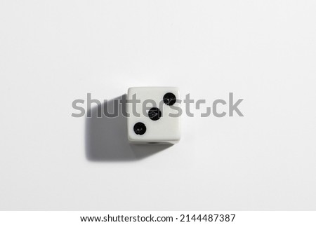 Single white dice with a three on a white background. Win or lose. Catch your luck. Gambling equipment.