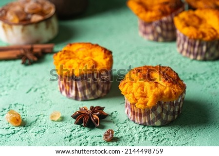Sweet homemade cottage cheese muffins with pumpkin on blue background