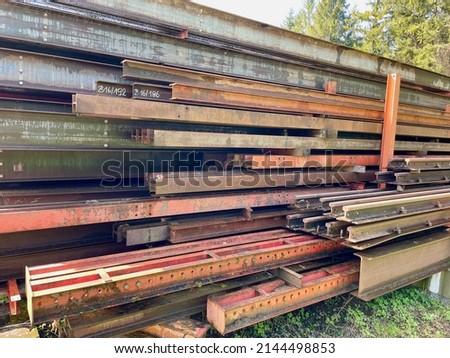 Piles of red steel beams in outdoor storage. High quality photo