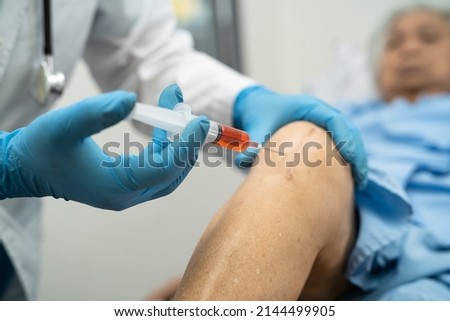 Asian doctor inject Hyaluronic acid platelet rich plasma into the knee of senior woman to walk without pain. Royalty-Free Stock Photo #2144499905