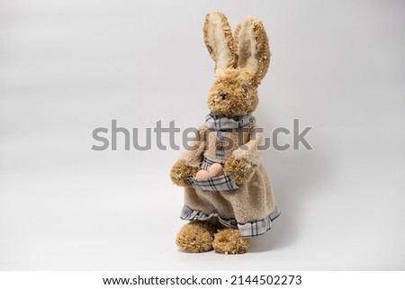 Easter Decorations Hare Rabbit of straw. Easter toy rabbit made of straw with a basket of egg isolated on a white background