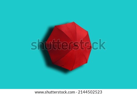 Top view, Single red umbrella isolated on cyan background, stock photo, invesment, business, summer concept