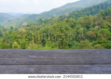 wood table top with mountain landscape background.