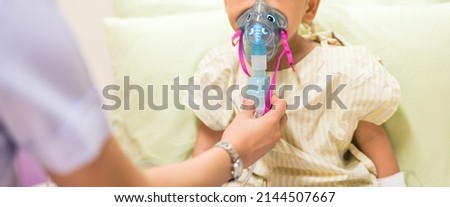 Nurse treat admitted patient boy by inhalation therapy with mask of inhaler. Sick little kid with RSV ,Respiratory Syncytial Virus, problem with oxygen mask breathes through nebulizer at hospital. Royalty-Free Stock Photo #2144507667