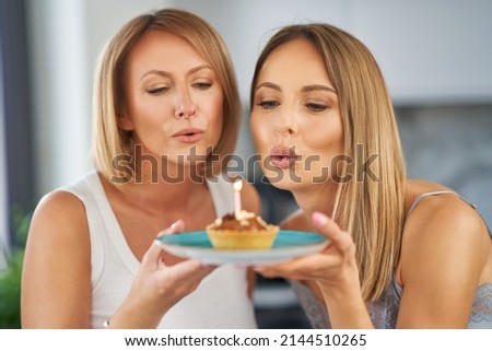 Nice two adult girls in the house with birthday cake