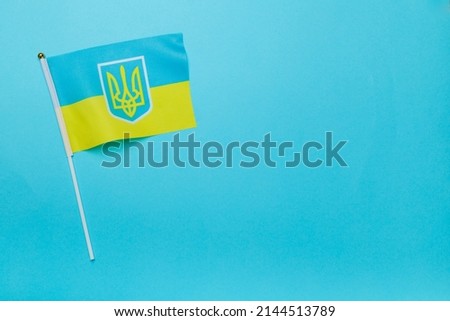 Ukraine flag on color background, top view.