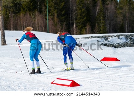 Female Cross Country Skiers racing, shallow depth of field.