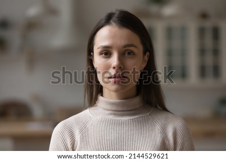 Positive serious millennial model girl home female head shot portrait. Beautiful young adult Caucasian woman looking at camera, posing in apartment. Front profile picture Royalty-Free Stock Photo #2144529621