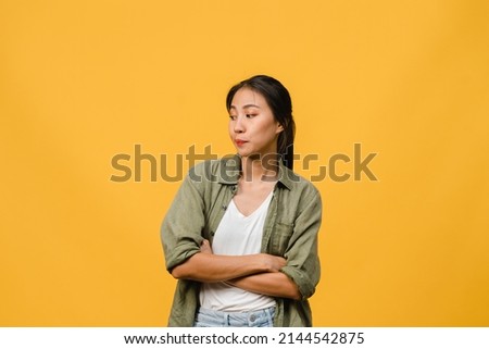 Portrait of young Asia lady with negative expression, excited screaming, crying emotional angry in casual clothing isolated on yellow background with blank copy space. Facial expression concept. Royalty-Free Stock Photo #2144542875