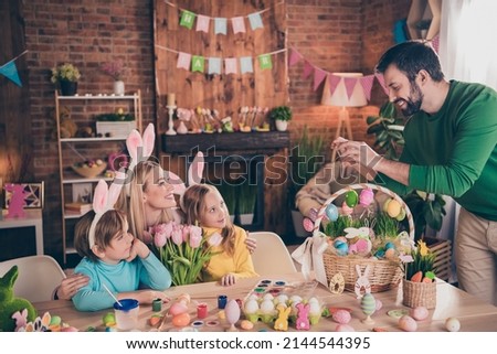 Photo of good mood family spend holiday weekend indoors daddy take picture of his family give mom flowers prepare easter holiday party