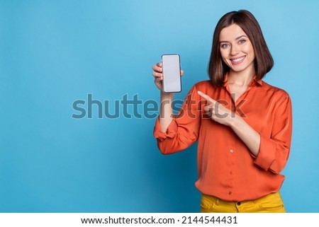 Portrait of attractive cheerful girl showing device gadget copy space ad offer isolated over bright blue color background