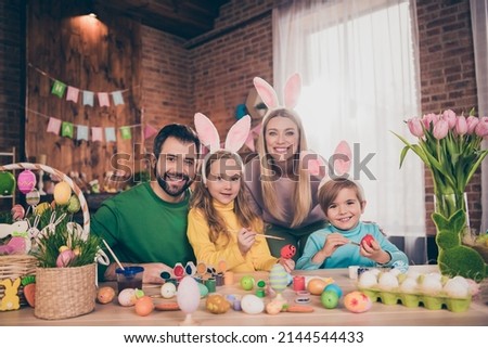 Photo of positive cheerful four people enjoy paint eggs prepare easter basket house indoors