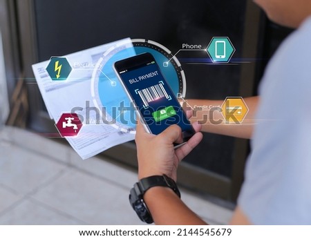 Online bill payment concept.Hands holding mobile phone to scan barcode on blurred Electric bill as background Royalty-Free Stock Photo #2144545679