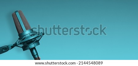 Studio microphone on blue background with copy space for broadcast or podcast website banner