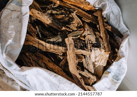 Pieces of peeled bark of an acacia tree, spruce lies in a bag close-up.