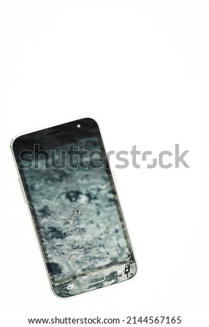 Broken cell phone on white background. Touchscreen smartphone with cracked lcd.