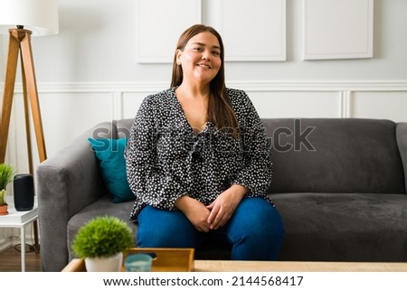 Portrait of an attractive hispanic woman with obesity smiling and feeling positive about herself Royalty-Free Stock Photo #2144568417